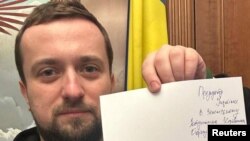 Кирилл Тимошенко держит заявление об отставкe. Cнимок, сделан в неизвестном месте и опубликован в социальных сетях 24 января 2023 года.