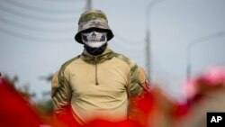 Боец ЧВК «Вагнера» стоит у неформального мемориала рядом с бывшим центром «ЧВК Вагнера» в Санкт-Петербурге, Россия, 24 августа 2023 г.